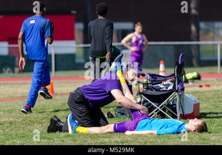 Medic behandelt verletzten Athleten. auf Schiene und Feld in Albany, NY treffen Stockfoto