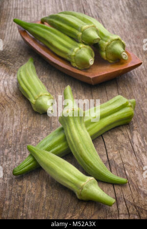 Frische Okra (Abelmoschus esculentus) auf hölzernen Tisch Stockfoto