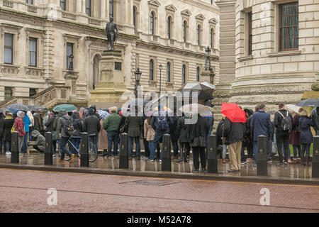 LONDON, UK, 10. Februar 2018: Die Menschen in der Linie im Regen mit Sonnenschirme für den Eingang von Churchill War Rooms in London warten. Stockfoto