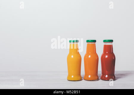 Drei Flaschen von Fruchtsäften auf weißem Hintergrund Stockfoto
