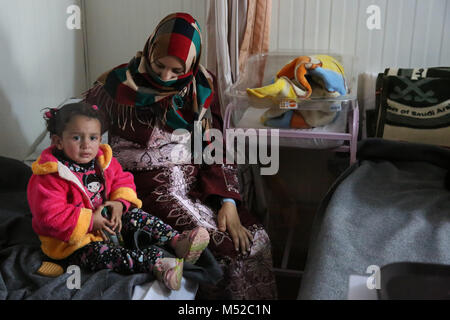 Eine Frau sitzt mit ihrem neugeborenen Baby an der UNFPA-run Mutterschaft Zentrum in Zaatari syrischen Flüchtlingslager. Durchschnittlich werden 70 Babys pro Monat sind dort geboren. Derzeit gibt es über 700.000 syrische Flüchtlinge in Jordanien die Flucht aus dem Konflikt in der Nation, die seit 2011 begonnen. Stockfoto