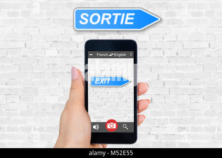 Person's Hand Handy mit Sprache Übersetzer Anwendung Stockfoto