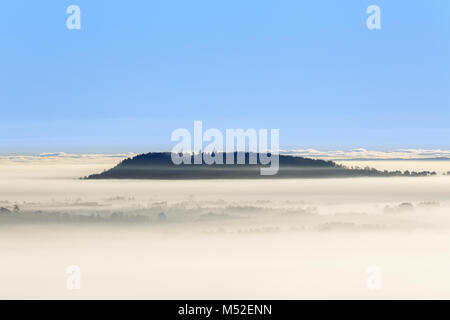 Nebeliger morgen Ansicht mit einem Berg über dem Nebel Stockfoto