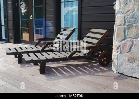 Zwei hölzerne Liegestühle auf der Terrasse Stockfoto