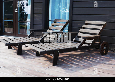 Zwei hölzerne Liegestühle auf der Terrasse Stockfoto