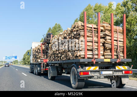 Großen Lkw mit Holz auf der Autobahn. Anhänger mit Brennholz Stockfoto