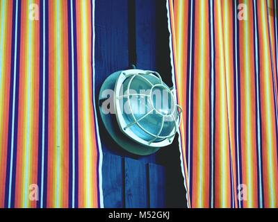 Zimmer an der Wand, mit farbenfrohen, gestreiften Vorhängen bedeckt. Winkte bunten Stoff Textur, Muster Streifen von Pastelltönen Stockfoto