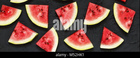 Scheiben der Reife Wassermelone auf einen schwarzen Stein Hintergrund Stockfoto