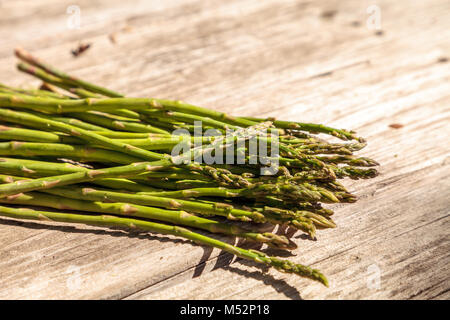 Frische dünne Spargel auf der rustikalen, mit Holz Hintergrund Stockfoto