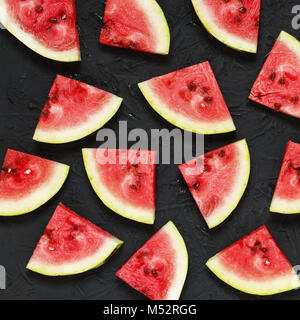 Scheiben der Reife Wassermelone auf einen schwarzen Stein Hintergrund Stockfoto