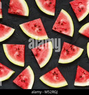 Scheiben der Reife Wassermelone auf einen schwarzen Stein Hintergrund Stockfoto
