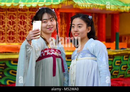 Zwei traditionell gekleidete chinesische Mädchen eine selfie während des Chinese New Year Parade feiern in London. Stockfoto