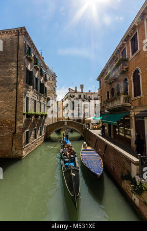 Die wunderschönen Venezianer Stadt Kanal Routen und Gondelfahrten, die Sun Flair in der Ecke der Altstadt Gebäude vor. Stockfoto