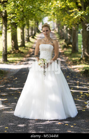 Junge blonde Frau im weißen Brautkleid Stockfoto
