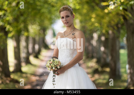 Junge blonde Frau im weißen Brautkleid Stockfoto