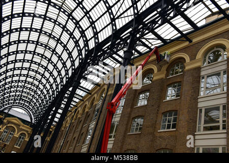 Männer bei der Arbeit oder Arbeit Arbeiter auf einem Cherry Picker oder mobile Hubsteiger Hays Galleria in London Bridge central Hauptstadt. Arbeiten in großer Höhe. Stockfoto