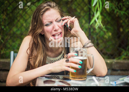 Frau oben brechen über Ihr Mobiltelefon Stockfoto