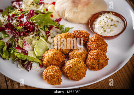 Falafel, frittierte Kugeln der Boden Kichererbsen mit bohnenkraut Sauce und Salat Stockfoto