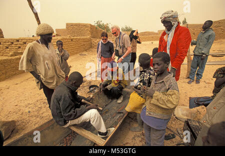 Mali. Bamba, Gao. Sahara. Sahel. Songhai, Songrai Stamm. Niger River. Männer Reparatur Boot. Touristen. Stockfoto