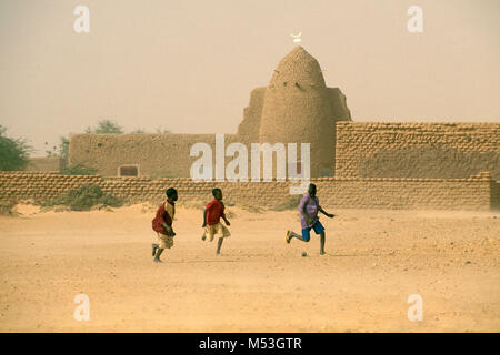 Mali. Bamba, Gao. Sahara. Sahel. Kinder spielen Fußball mit Baumwolle Kugel vor der Moschee. Stockfoto