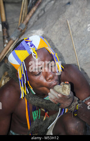 Hadza Mann rauchen von einem traditionellen tonpfeifen fotografiert in der Nähe von Lake Eyasi, Tansania, Afrika Stockfoto