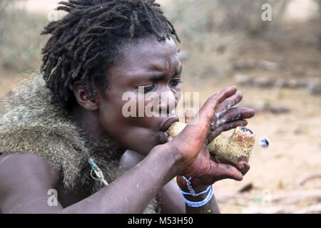 Hadza Mann rauchen von einem traditionellen tonpfeifen fotografiert in der Nähe von Lake Eyasi, Tansania, Afrika Stockfoto