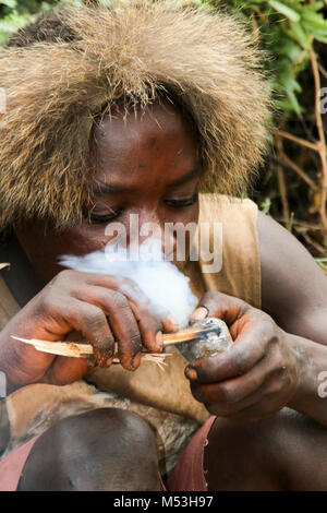 Hadza Mann rauchen von einem traditionellen tonpfeifen fotografiert in der Nähe von Lake Eyasi, Tansania, Afrika Stockfoto