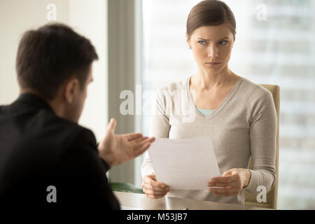 Manager versuchen, zweifelhaft, weibliche Kunden zu überzeugen Stockfoto