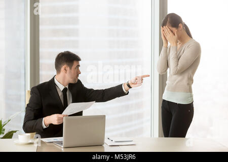Boss wirft weiblicher Manager in schlechte Arbeitsergebnisse Stockfoto