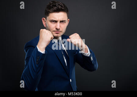 Mad Geschäftsmann beeing bereit für Kampf und Dorn, jemand mit der Faust auf dunklem Hintergrund isoliert Stockfoto