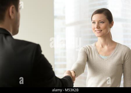 Attraktiven weiblichen Mitarbeiter handshaking mit Chef Stockfoto