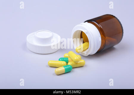 Bunte medizinische Pillen und Kapseln auf weißen Tisch mit Platz für Text. Stockfoto