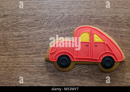 Nahaufnahme von roten Lebkuchen Auto gelegen auf dem hölzernen Tisch Hintergrund Stockfoto