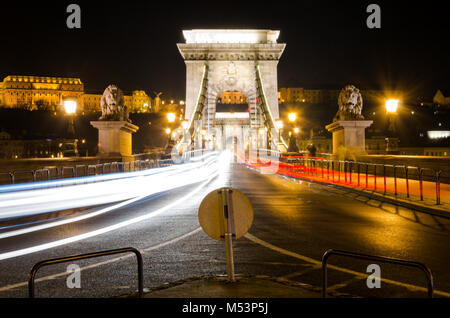 Nachtaufnahme beleuchteter Kettenbrücke über die Donau, Budapest, Ungarn. Rote und weiße Auto Wanderwege, Langzeitbelichtung Stockfoto