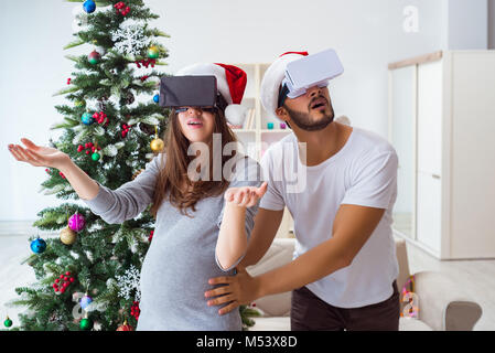 Junge Familie erwartet Kind Baby tragen Virtuelle Realität VR gla Stockfoto