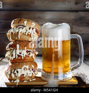 Eine Tasse helles Bier und einem riesigen Burger Stockfoto