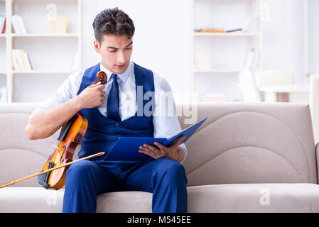 Junge Musiker Mann spielen Geige Üben zu Hause Stockfoto