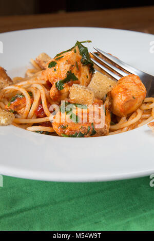 Traditionelle italienische Stil brauner Butter Linguini mit Chili gewürzte Huhn Stücke in einer Tomaten und Basilikum Sauce garniert mit Knoblauch Brot Croutons Stockfoto