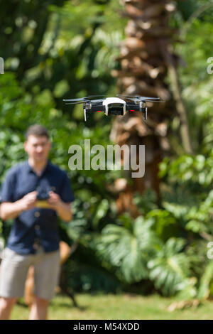 Eine DJI Mavic Luft Drohne im Flug mit einem Mann it-controlling im Hintergrund Stockfoto