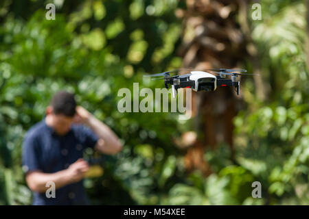 Eine DJI Mavic Luft Drohne im Flug mit einem Mann suchen Sie verwirrt Fliegen im Hintergrund Stockfoto