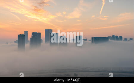 Abu Dhabi Nebel Sonnenaufgang. Morgen Ansicht der Hochhäuser auf Reem Island in Abu Dhabi, Hauptstadt der Vereinigten Arabischen Emirate Stockfoto