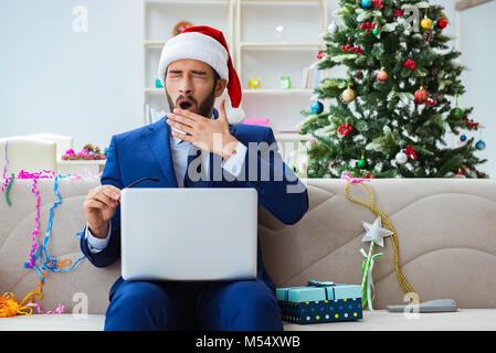 Der Geschäftsmann zu Hause während Weihnachten arbeiten Stockfoto