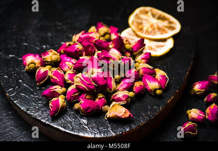 Rose Kaffee Knospen und Zitronenscheiben auf dunklen Platte Stockfoto