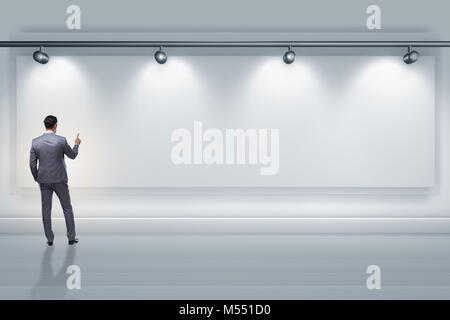 Geschäftsmann drücken virtuelle Taste auf der Wand beleuchtet mit spotlig Stockfoto