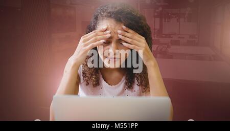 Frau Arbeiten am Laptop betonte Holding Kopf Stockfoto