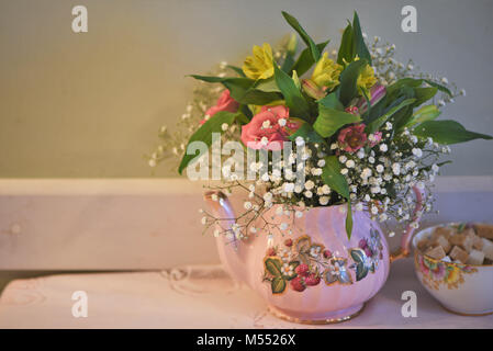 Vintage Teekanne und Sugar Bowl auf einem Tisch mit frischen Blumen gefüllt Stockfoto