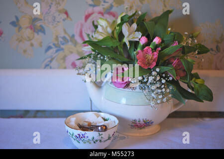 Vintage Teekanne und Sugar Bowl auf einem Tisch mit frischen Blumen gefüllt Stockfoto