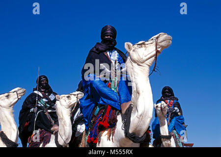 Algerien. In der Nähe von Tamanrasset. Sahara. Männer von Tuareg Stamm auf ihren Kamelen. Indigo Blue turbans. Stockfoto