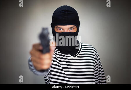 Terroristische ware Maske und halten Sie die Pistole, Gewehr, in der Hand für Rob Asset oder ein Verbrechen machen Stockfoto