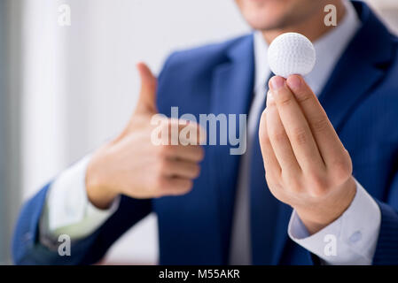 Junge Unternehmer mit Golf ball Arbeiten im Büro Stockfoto